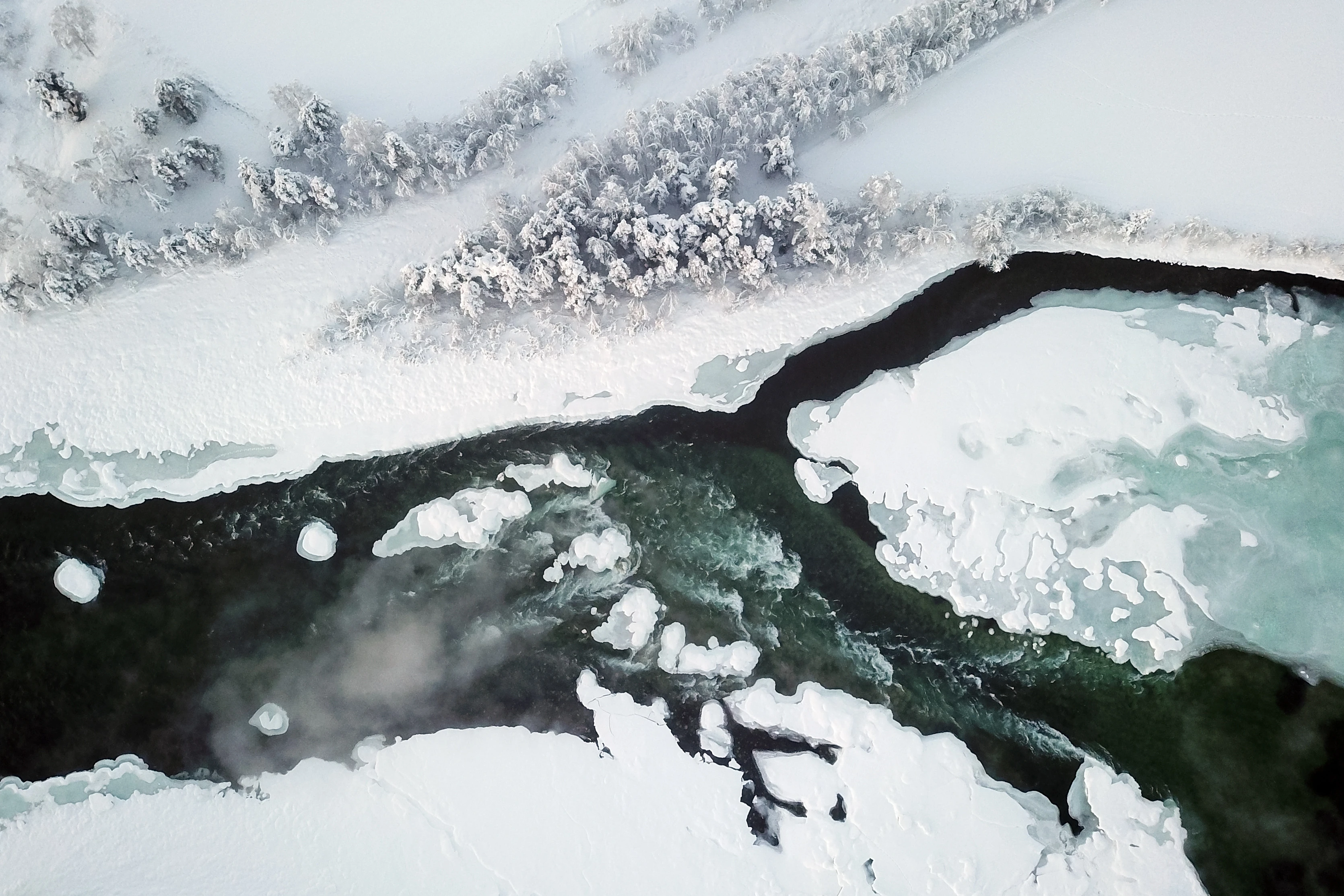 Elv som renner gjennom et vinterlandskap.